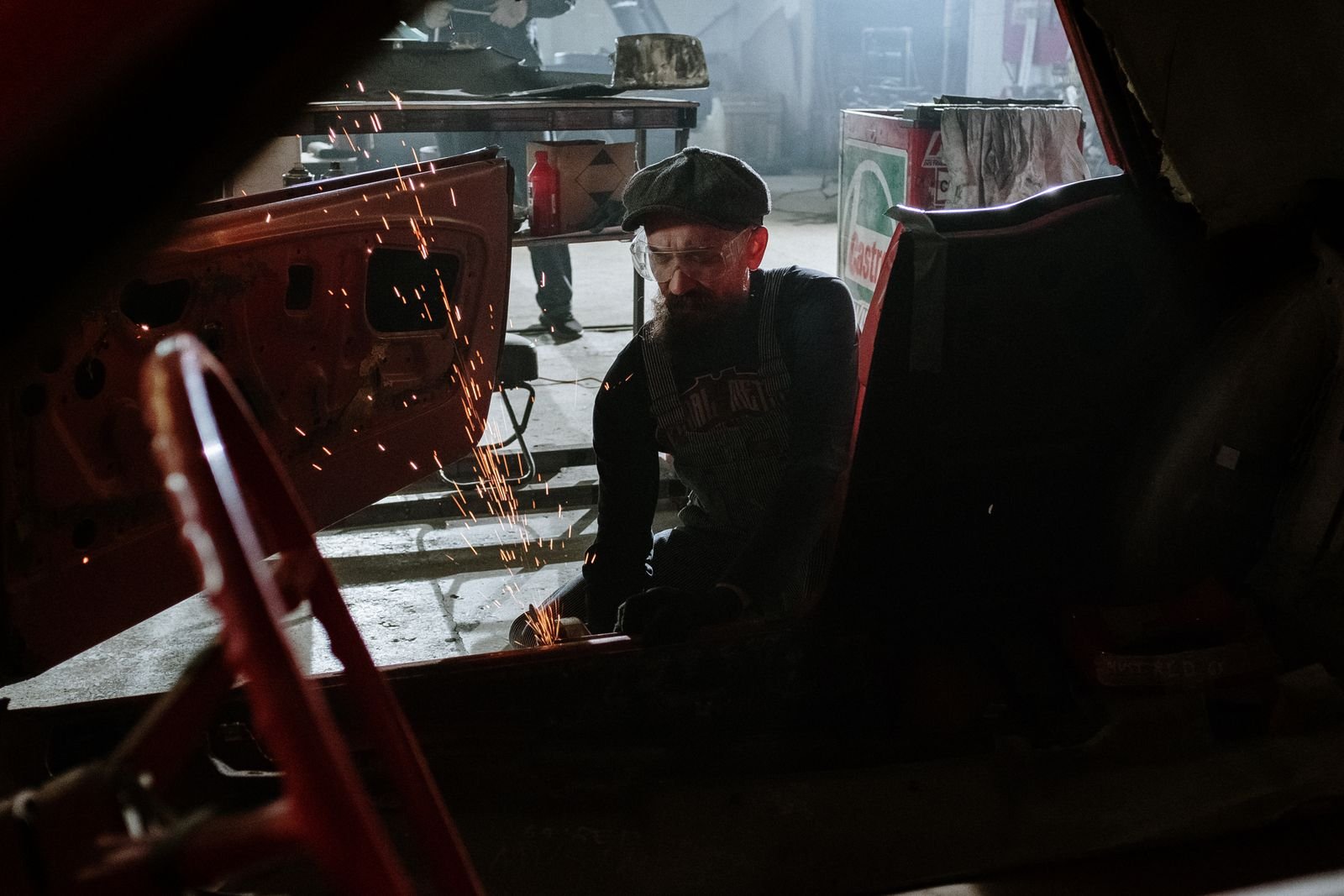 Technician welding and restoring a vehicle body in the workshop