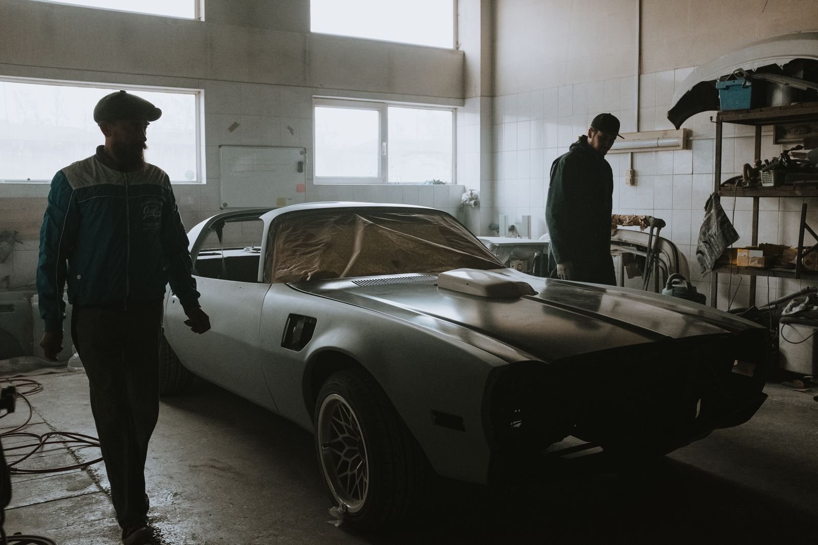 Classic car body restoration in progress inside a workshop